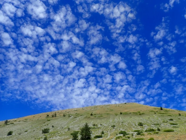 Moutonnement de petits nuages au-dessus d'un sommet.