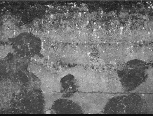 Photographie en noir et blanc de trois silhouettes humaines sur une façade en pierre.