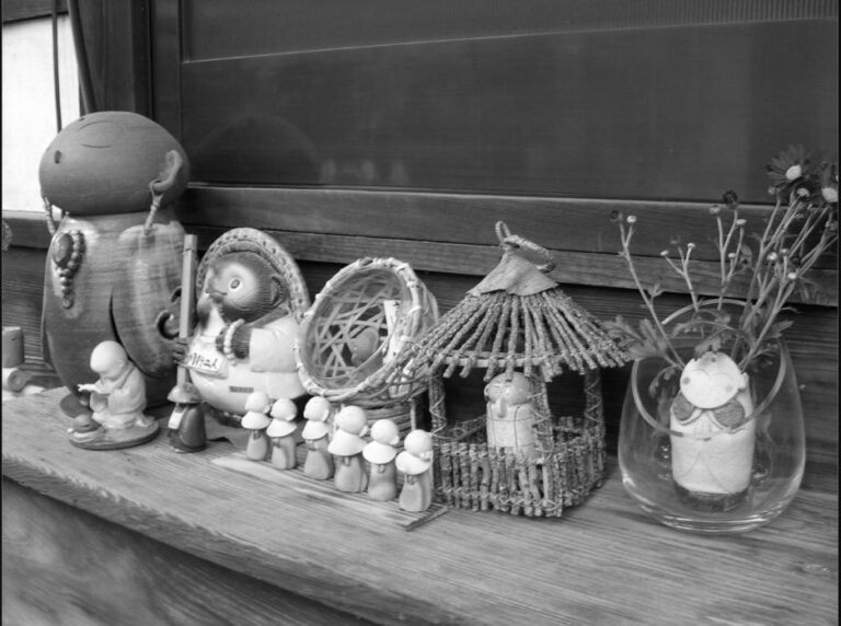 Petites statuettes de Jizôs et de tanuki posées sur un rebord de fenêtre au Japon.